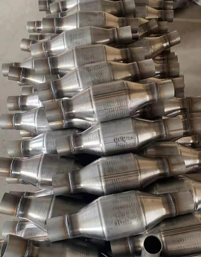 Catalytic converters neatly stacked, showcasing their metallic design and precision craftsmanship, essential components of car exhaust systems.